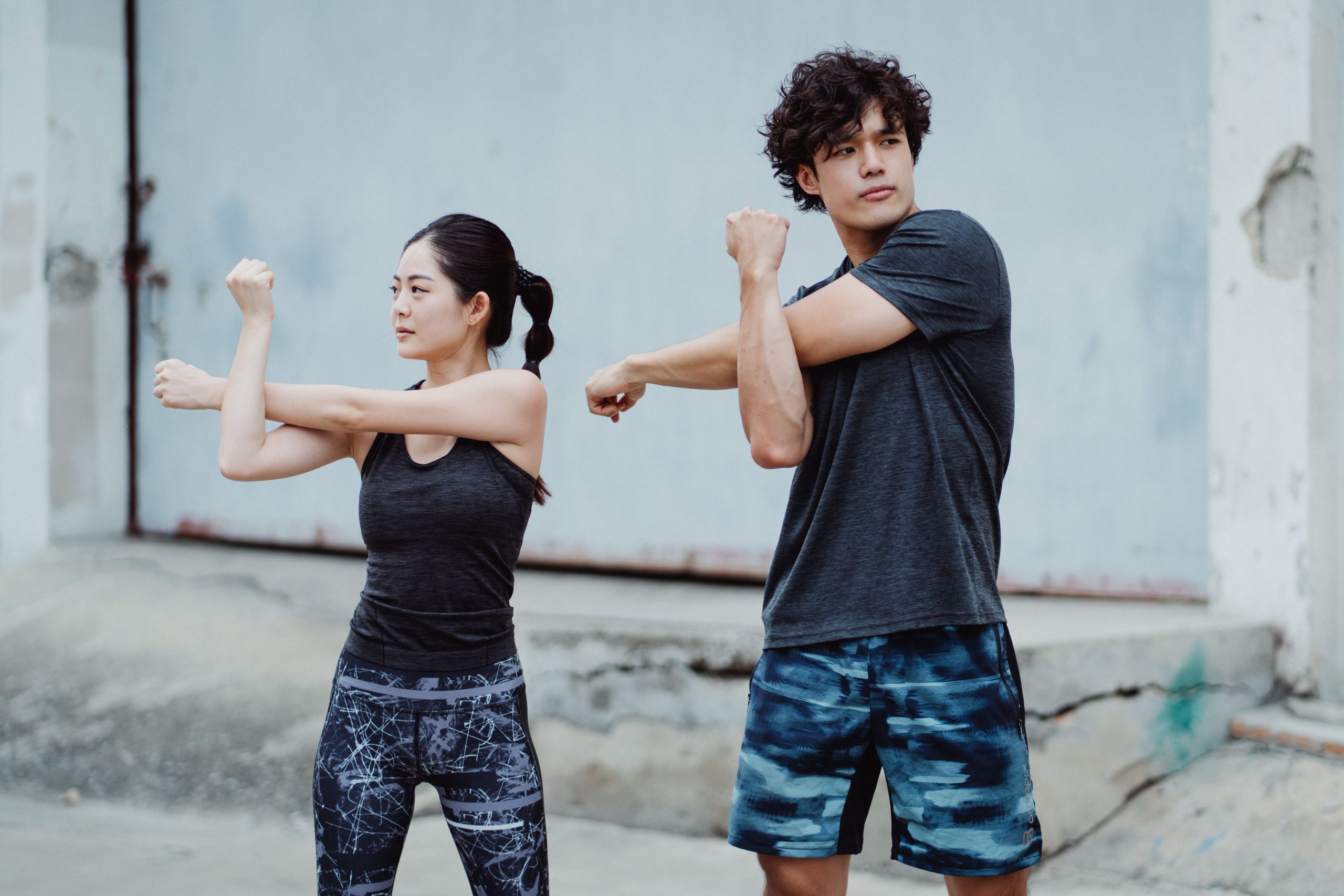 Jeune couple en tenue de sport s'etire dehors