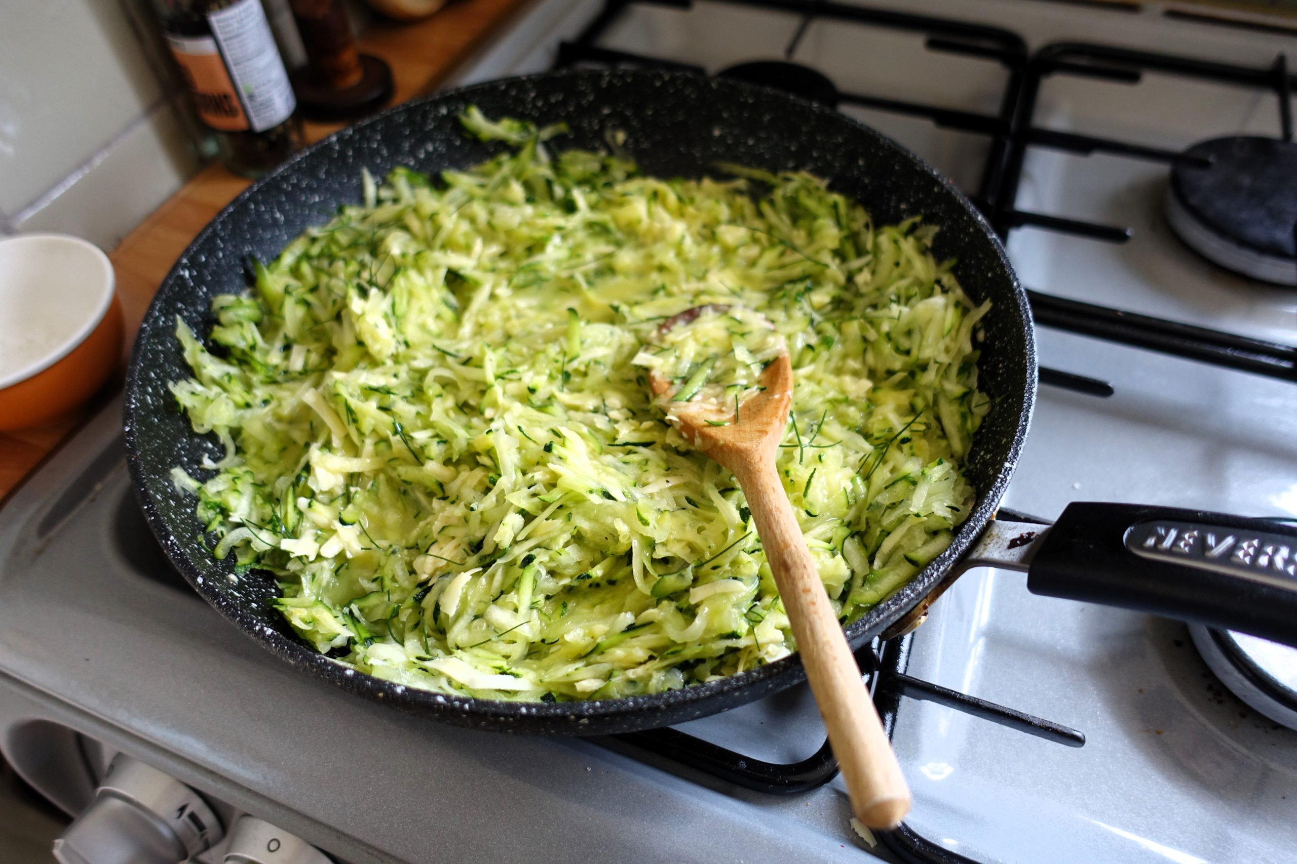 Courgettes râpées cuisant dans une poêle