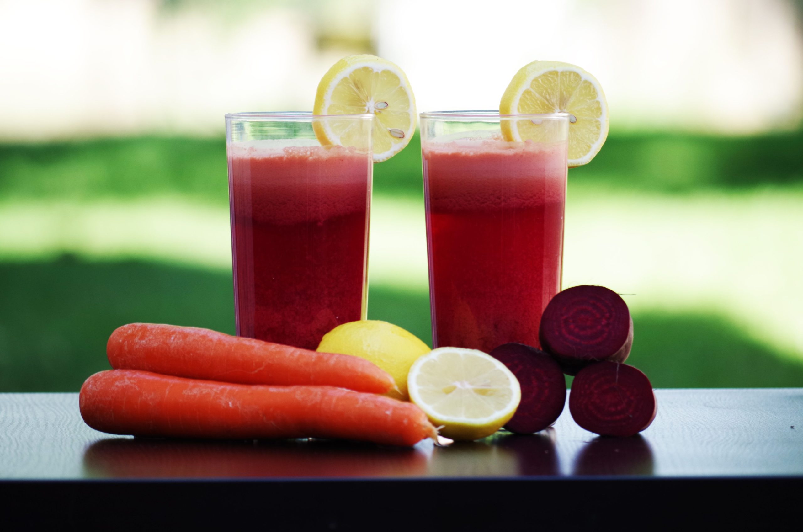 Verres colorés de jus betterave et carotte citron