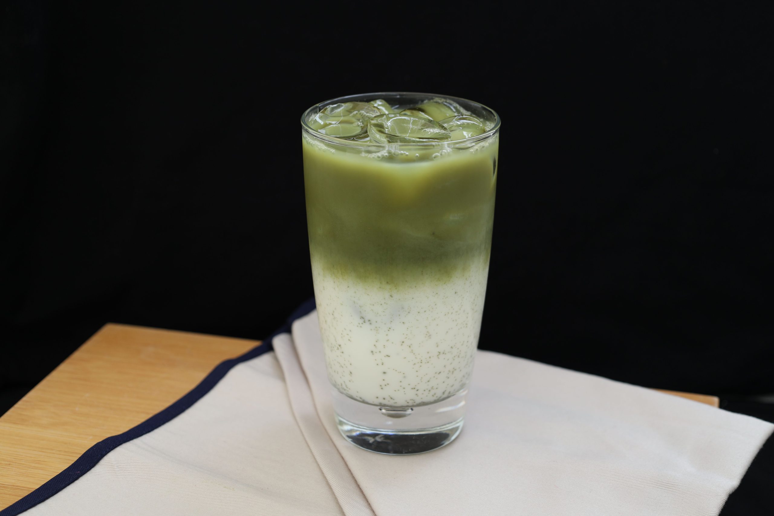 Matcha latte glacé avec lait sur table bois