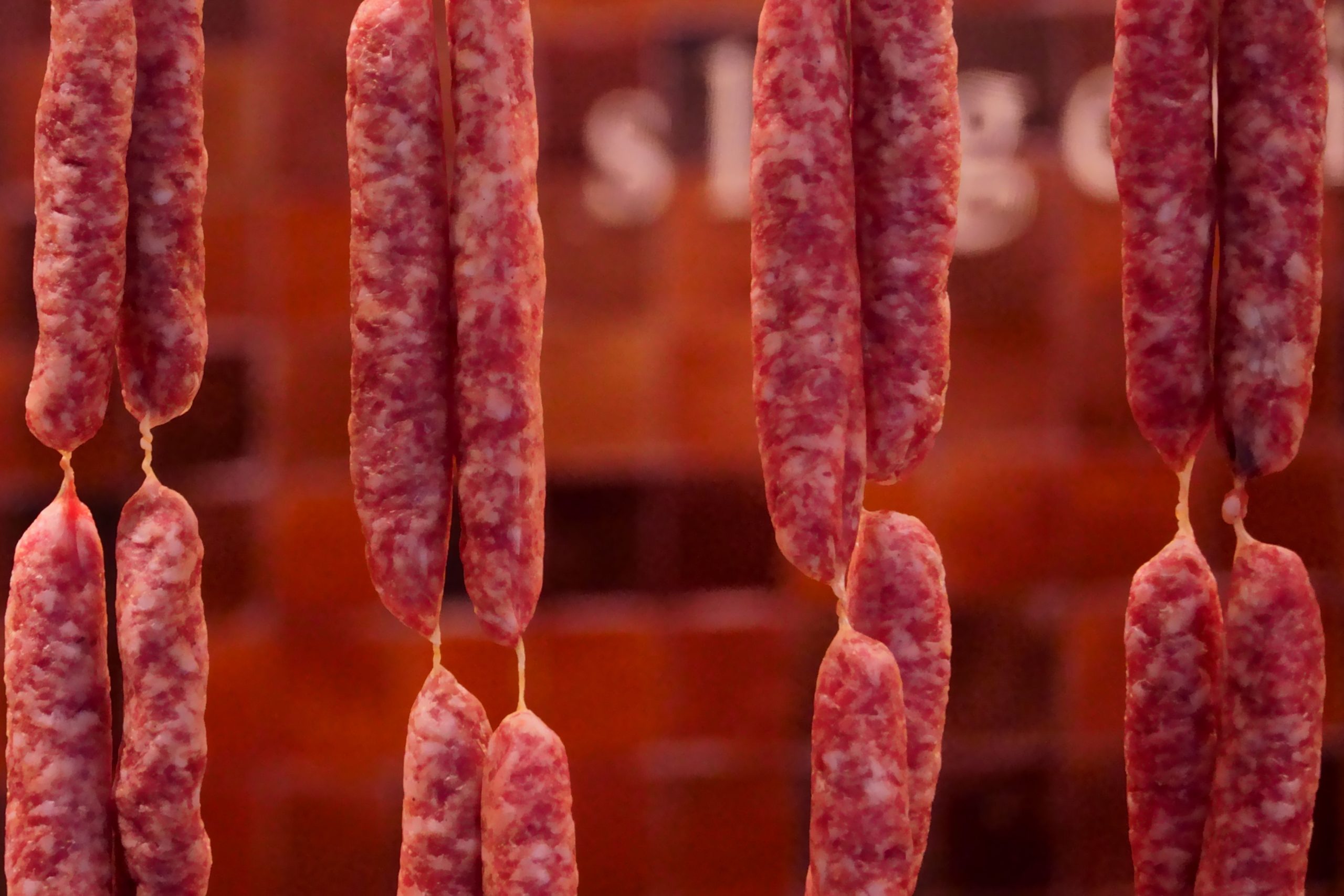 Saucisses fumées suspendues en boucherie traditionnelle