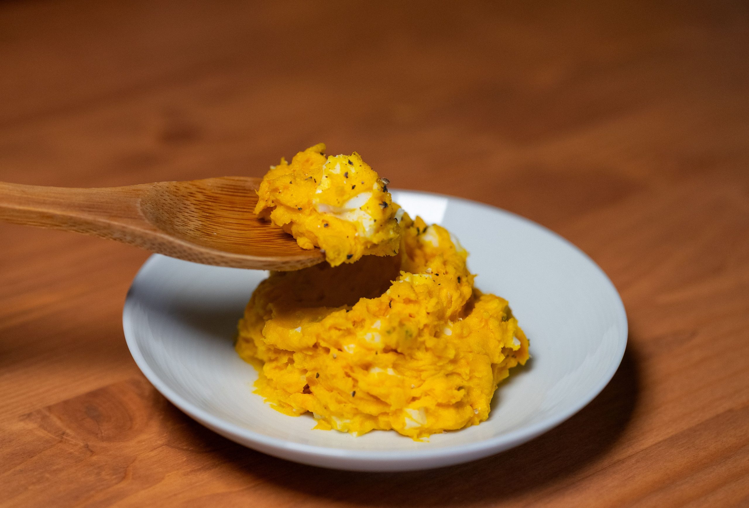 Purée de courge crémeuse servie avec une cuillère en bois