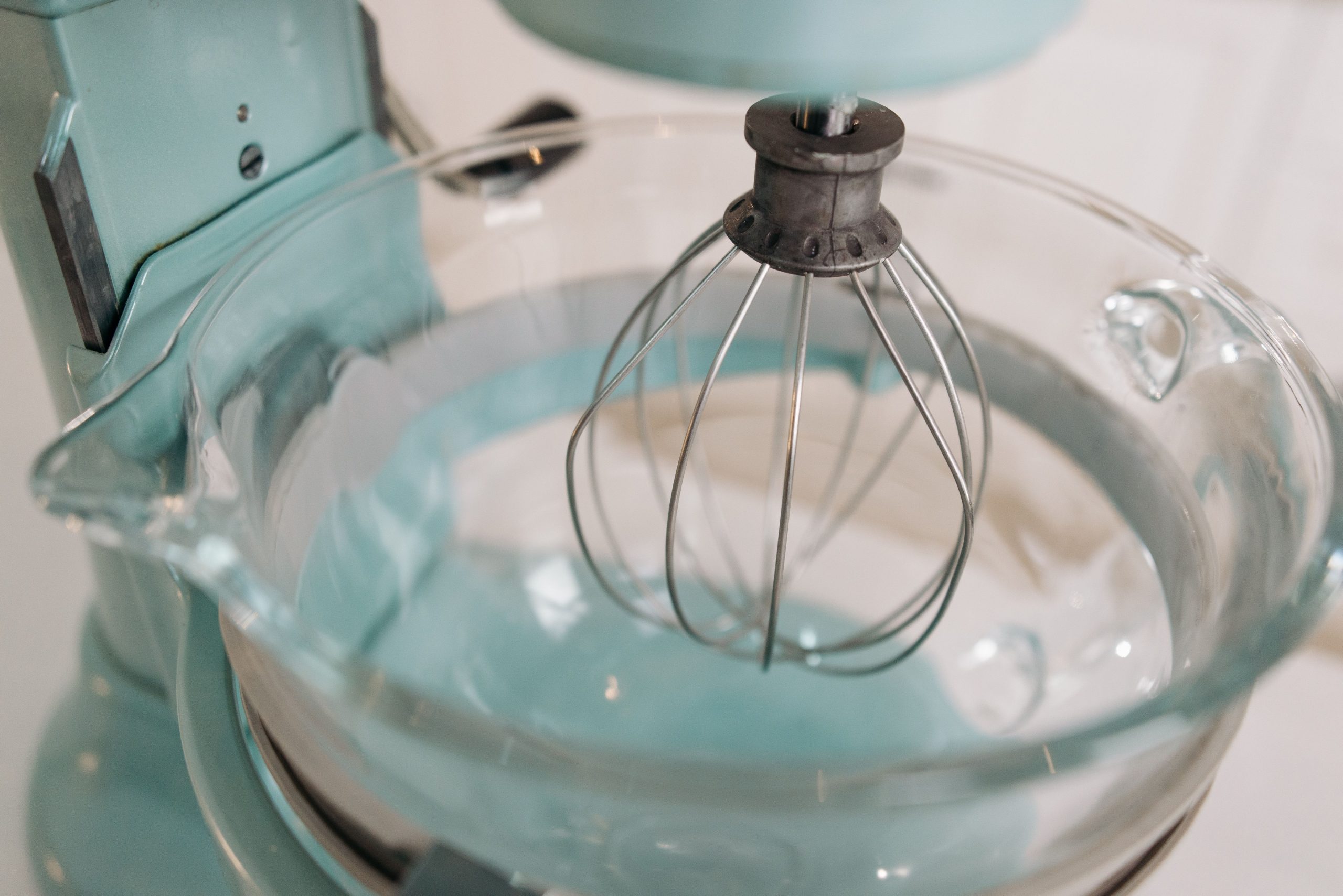 Robot pâtissier turquoise avec fouet et bol en verre